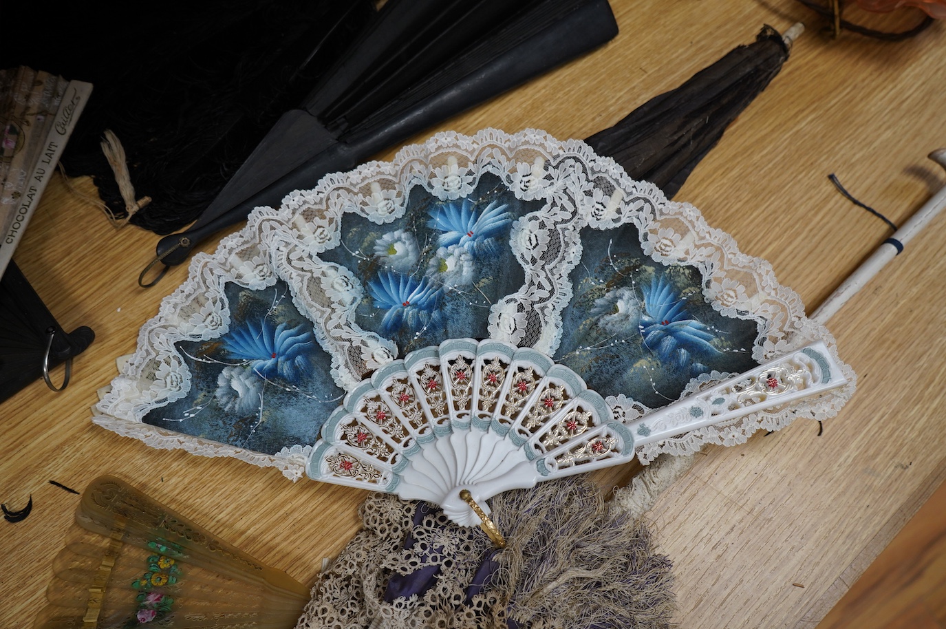 A group of 19th/20th century fans and two parasols, largest fan 33cm, (14). Condition - poor to fair.